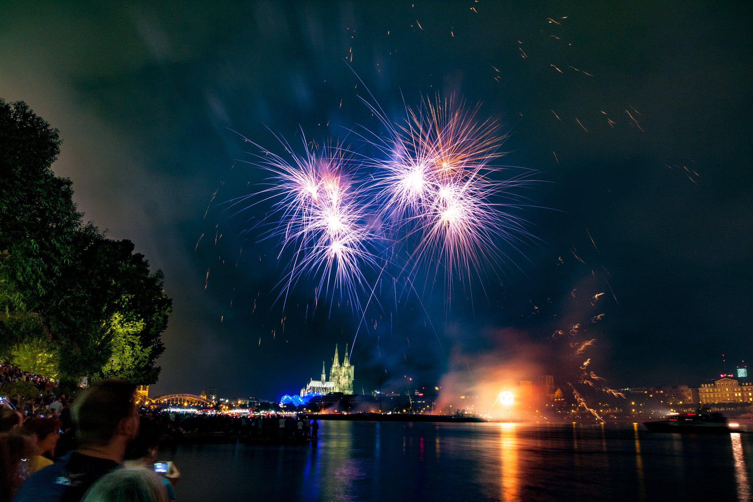 Long exposure of purple fireworks over the Rhine with the Cologne Cathedral.