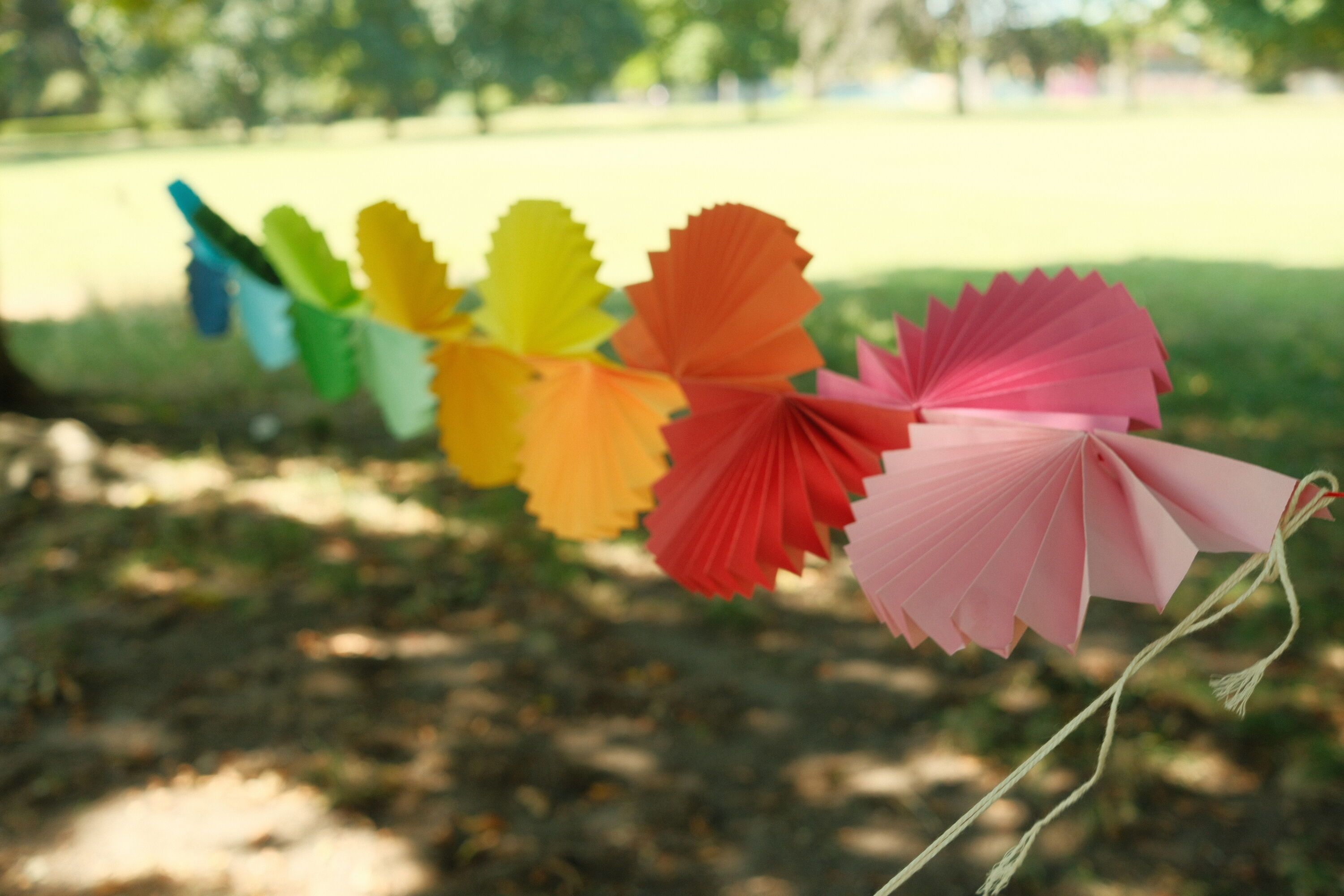 A ribbon of rainbow-colored folded paper stretches diagonally into the distance.